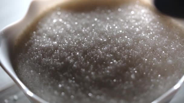 Close-up shot van witte suiker in een glas schotel - Video