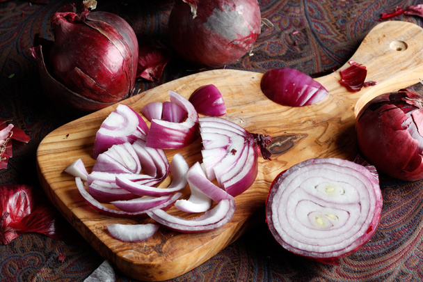 Elegant red onion on a cutting board - Фото, изображение