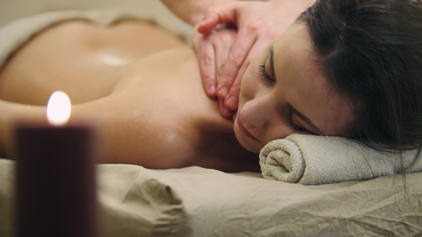 Mulher jovem semi-nua na mesa de massagem no salão de spa - massagem relaxante a óleo, conceito de spa
 - Foto, Imagem