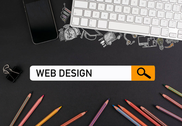Web ontwerpconcept. kleurrijke potloden en een toetsenbord van de computer met een mobiele telefoon op een zwarte lijst - Foto, afbeelding