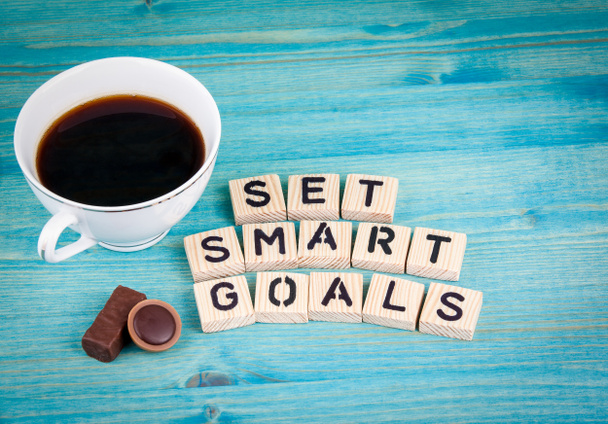 Állítsa be a smart célok. Kávé bögre és fából készült levelek, a fa háttér - Fotó, kép