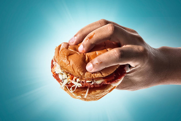Fast food en dieet. Handen houden de hamburger - Foto, afbeelding