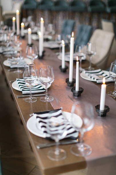 Wedding decor. Wedding interior. Festive table decor, layout. Restaurant interior. The burning candles on a table. - Foto, Imagen