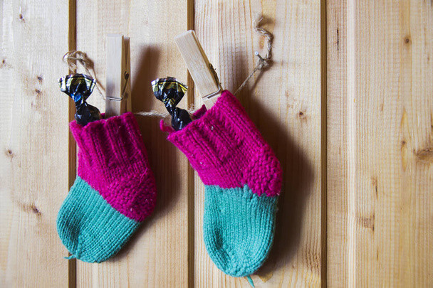 Baby knitted socks on baby hang on rope on clothespins - Photo, Image