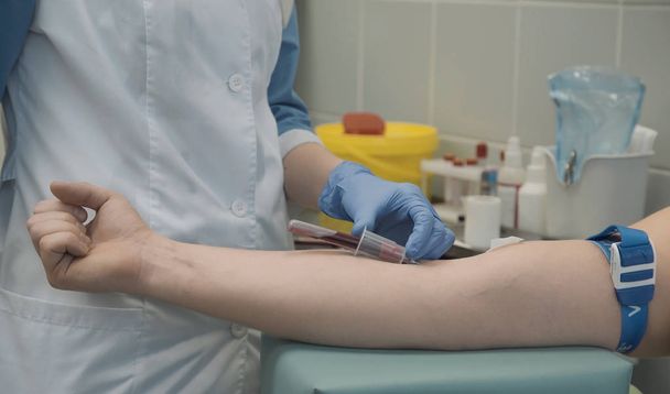 Enfermeira tira amostras de sangue do paciente
 - Foto, Imagem