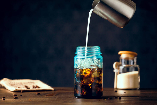 Milk Pouring Into Iced Organic Coffee Served In Blue Mason Jar - Zdjęcie, obraz