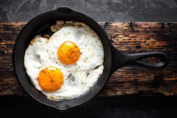 Frying pan with fried eggs isolated Royalty Free Vector