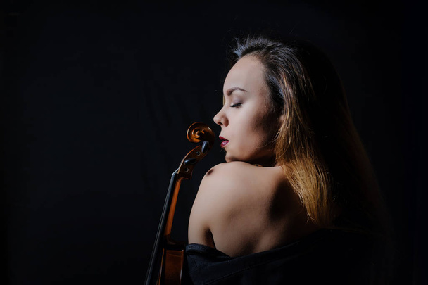 Beautiful young woman playing violin - Fotó, kép