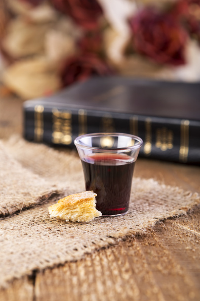 Taking Communion. Cup of glass with red wine and bread. - Photo, Image