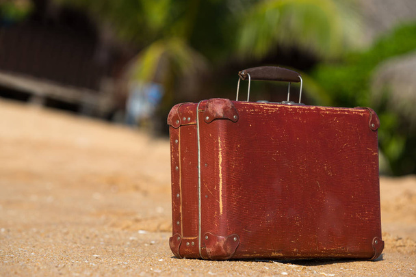 Travel  vintage suitcase is alone on a beach - Фото, зображення