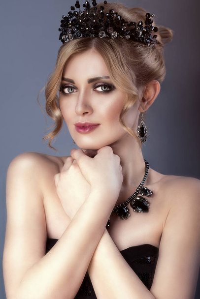 Portrait de beauté de magnifique modèle blond avec cheveux updo et couronne de bijoux noirs portant haut bretelles paillettes et ensemble de collier luxueux et boucles d'oreilles
 - Photo, image