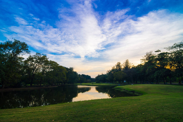 Parque con estanque puesta del sol cielo colorido, Parque público natural
 - Foto, Imagen
