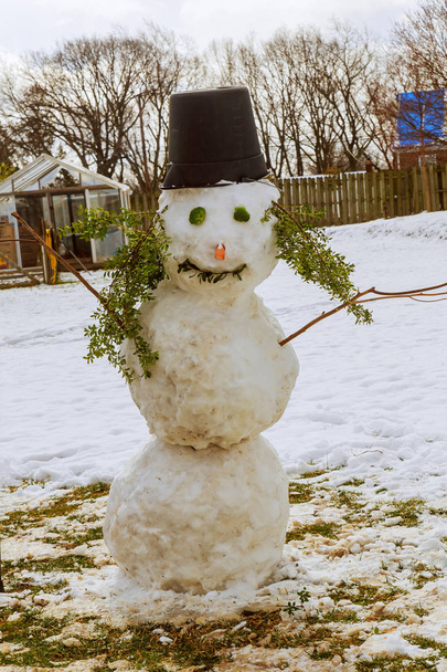 We bouwden een sneeuwpop en kleedde het in een sjaal. Baba sneeuw beeldhouwen met sneeuw - Foto, afbeelding