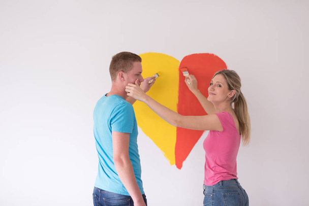 couple painting heart on wall - Zdjęcie, obraz