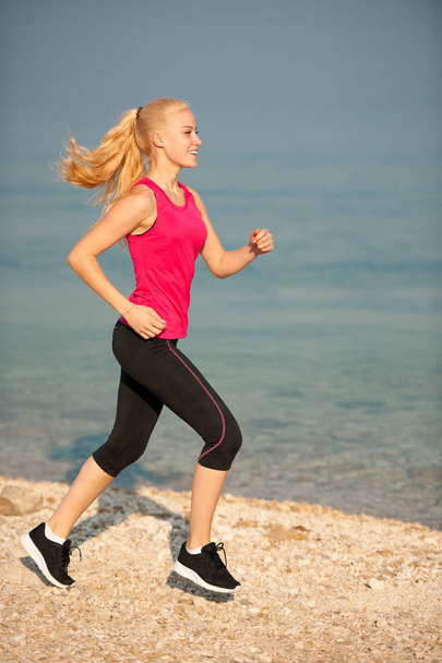 jogging th beach - nő runns a nyár elején reg-tenger közelében - Fotó, kép
