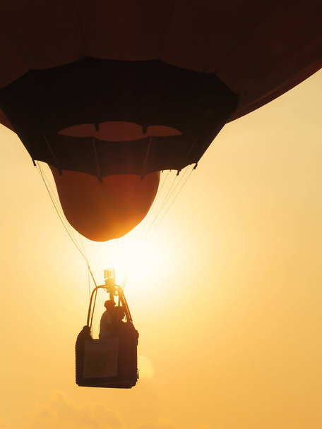 Silueta de personas en canasta de globos en el cielo
 - Foto, imagen
