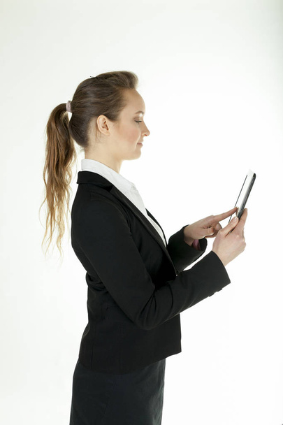  Joven mujer de negocios con tablet ordenador de pie de lado
 - Foto, Imagen