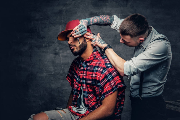 Barbier tatoué coupant la barbe
 - Photo, image