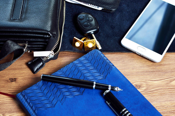 Accessoires d'affaires sur le bureau : sac, montre, stylo, parfum, bouton de manchette et téléphone. Succès en affaires
. - Photo, image