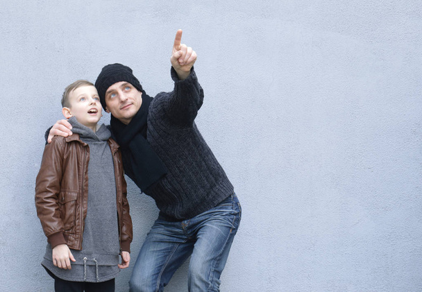 Man and boy (father and son) posing on a gray background - Fotoğraf, Görsel