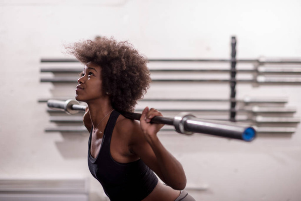 black woman lifting empty bar - Foto, imagen