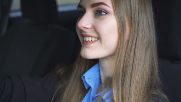 Young brunette woman paints her lips in the car. 4K - Filmati, video