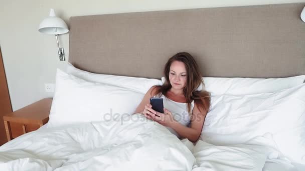 Woman Lying In Bed Checking Messages On Mobile Phone - Video, Çekim