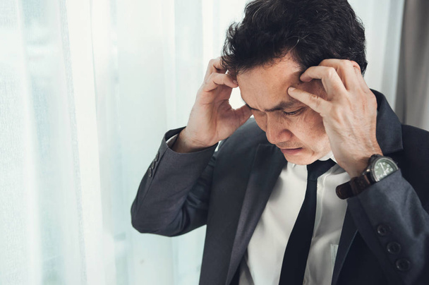 Asian businessman has headache from migraine from overworked. Il - Foto, afbeelding