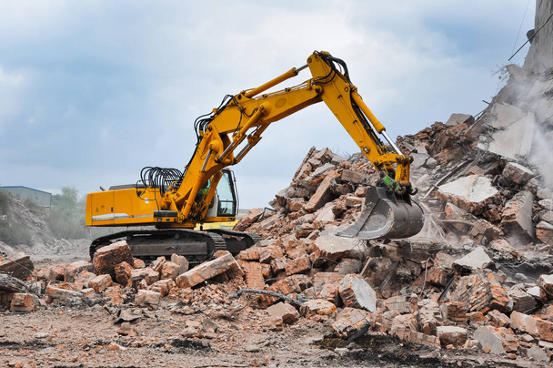 Excavadora que trabaja en la demolición de un antiguo edificio industrial
 - Foto, Imagen
