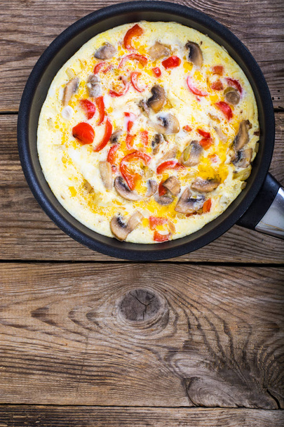 Frittata met champignons en paprika in een koekenpan - Foto, afbeelding