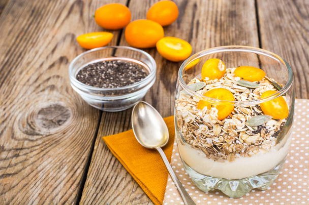 Desayuno saludable, avena con kumquats, granola, yogur, chía
 - Foto, Imagen