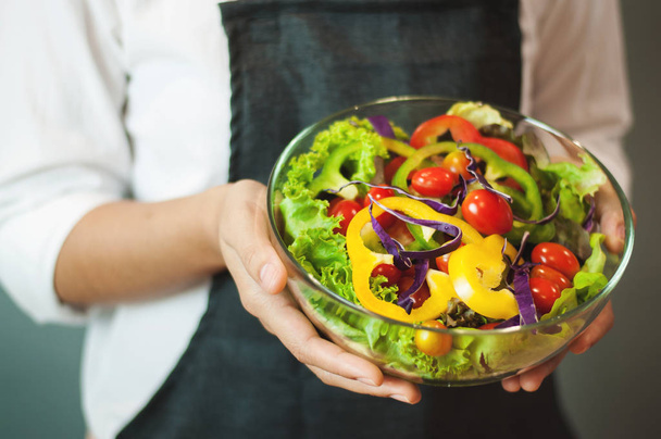 Woman holding salad in glass bowl. - Photo, Image