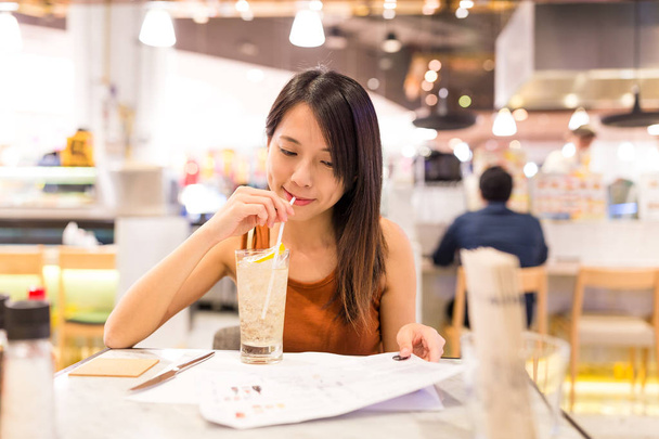 Vrouw geniet van haar drankje in het restaurant - Foto, afbeelding