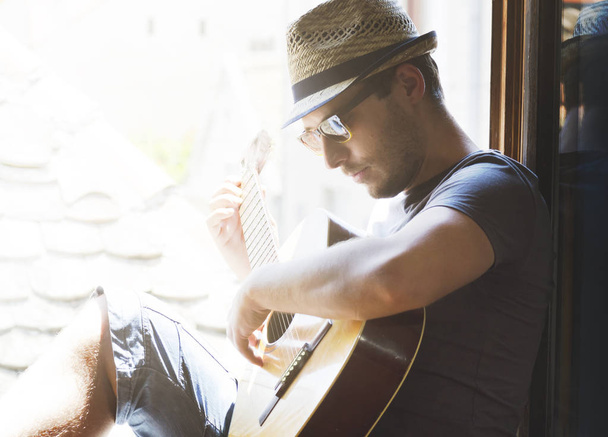 Jonge hipster man speelt gitaar - Foto, afbeelding