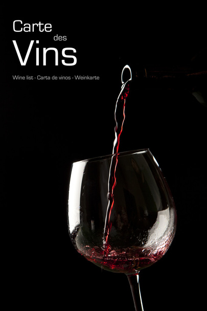Red wine splash on a glass on black background. - Foto, imagen