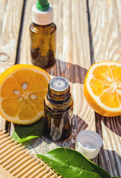 Aceite esencial de limón en una botella pequeña. Enfoque selectivo.  - Foto, Imagen