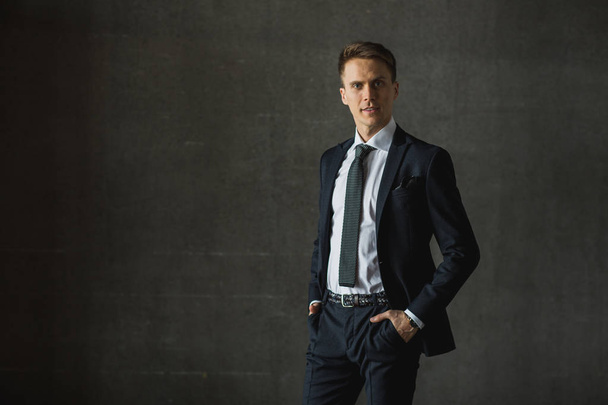 Hombre de negocios guapo en traje formal sobre fondo gris
 - Foto, imagen