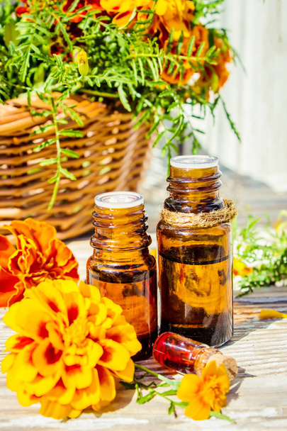 Essential oil of chernobrivtsev, marigold in a small bottle. Selective focus.  - Photo, Image
