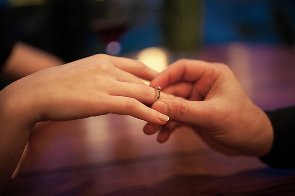 Young man makes woman marriage proposal and puts an engagement r - 写真・画像