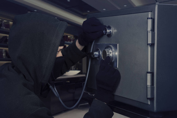 Burglar with bank vault and stethoscope - Foto, imagen