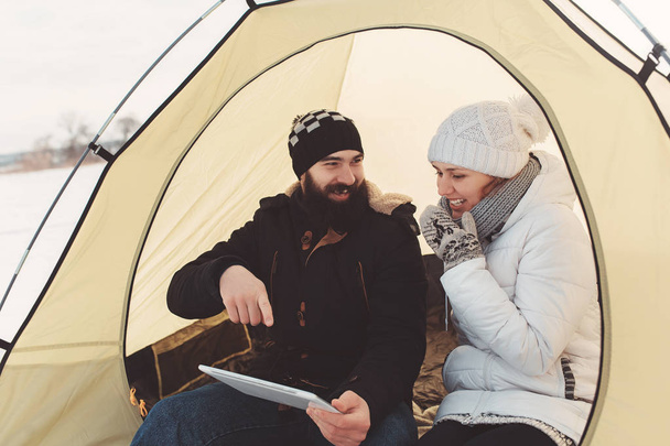 Teenagers with tablet sit in tent and communicate in social networks - Fotó, kép