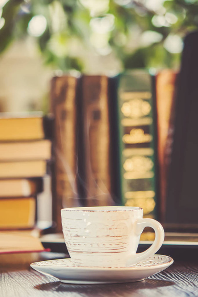 Koffie ochtend op de werkplek. met een boek of een laptop. selectieve aandacht. - Foto, afbeelding