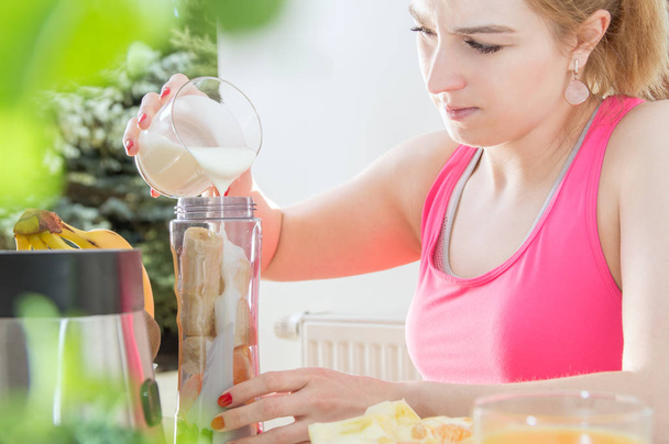 Donna atletica tiene uno yogurt sul tavolo con cibo sano
 - Foto, immagini
