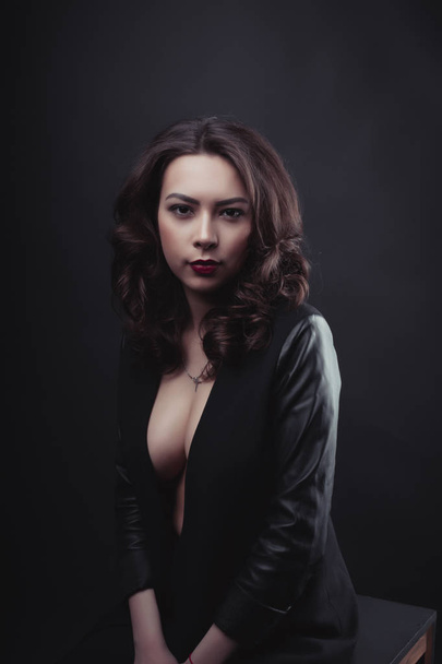 Fashionable brunette woman with curly hair wearing leather jacke - Foto, Imagem