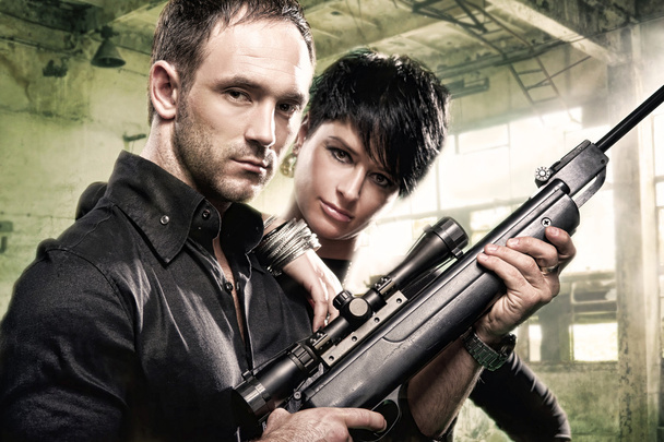 Lovely couple with gun in factory - Foto, Imagen