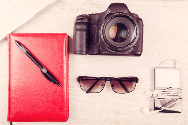 Камера, ноутбук, цифровой стол, записная книжка и солнечные очки
  - Фото, изображение