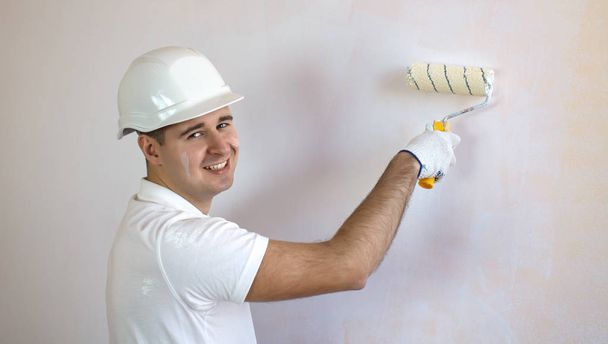 Close up view of smiling man holding paint roller - Foto, Imagem