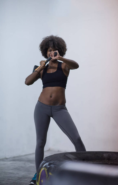Woman workouting with hammer  - Фото, зображення