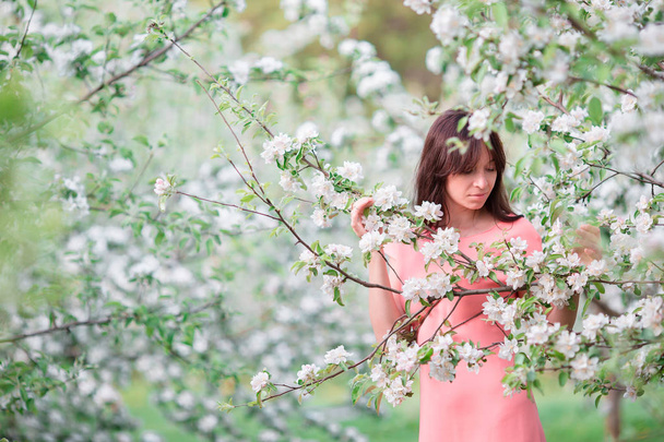 Beautiful woman enjoying smell in spring cherry garden - Фото, зображення