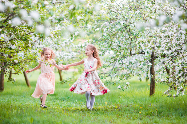 Meninas bonitas em flor macieira jardim desfrutar quente dia de primavera
 - Foto, Imagem